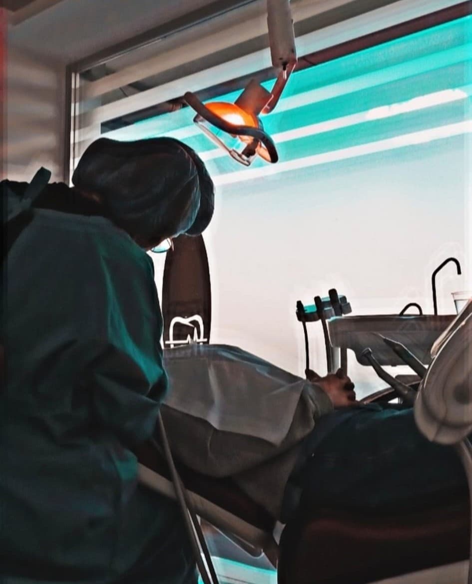 A dentist at work under the treatment light